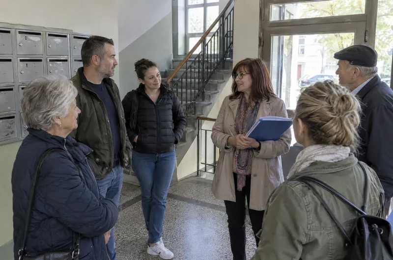 Stanari zgrade razgovaraju u ulazu o predlogu za punjač